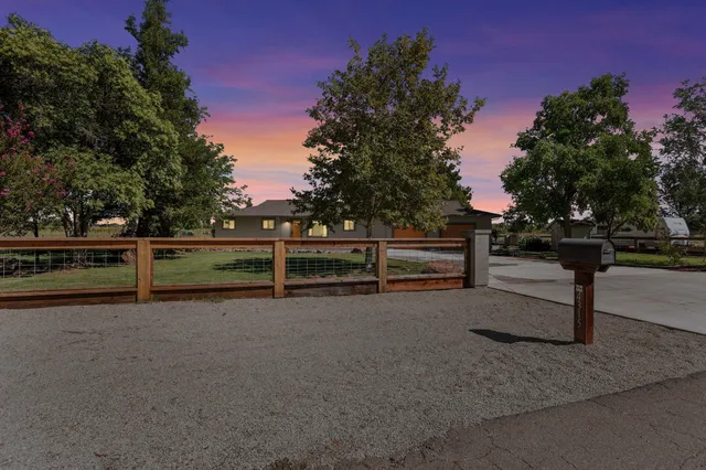a view of backyard with wooden fence and large trees