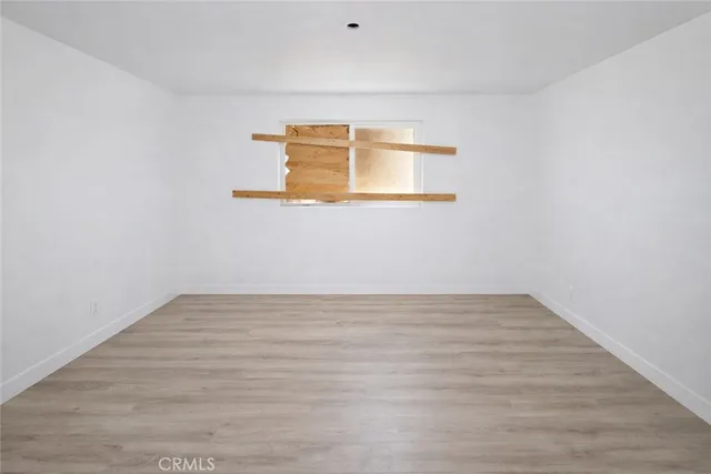 a view of a small space with wooden floor and a window