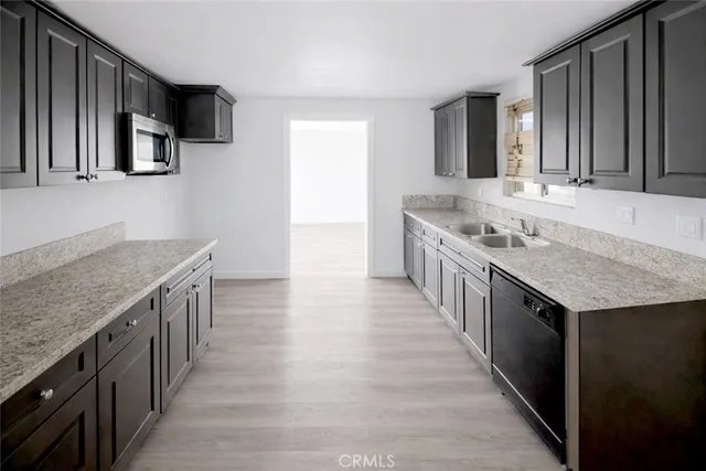 a kitchen with stainless steel appliances granite countertop a kitchen island a stove and a sink