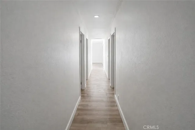 a view of a hallway with wooden floor
