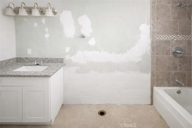 a bathroom with a granite countertop sink a toilet and bathtub
