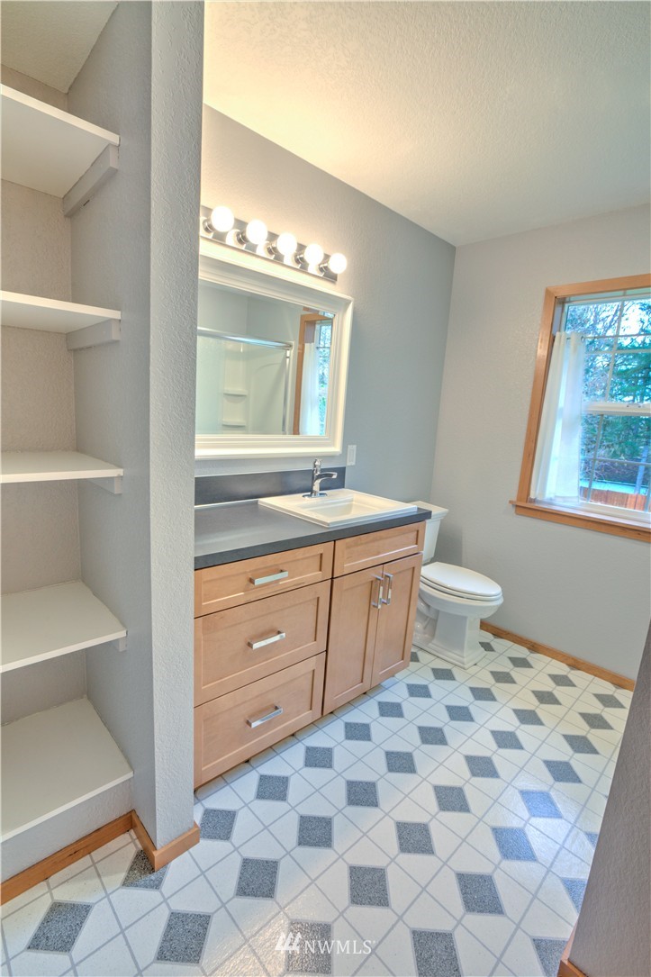 7736 Fairview Road Southwest Tumwater, WA 98512 - Photo 16 of 25 a bathroom with a sink a toilet and a mirror
