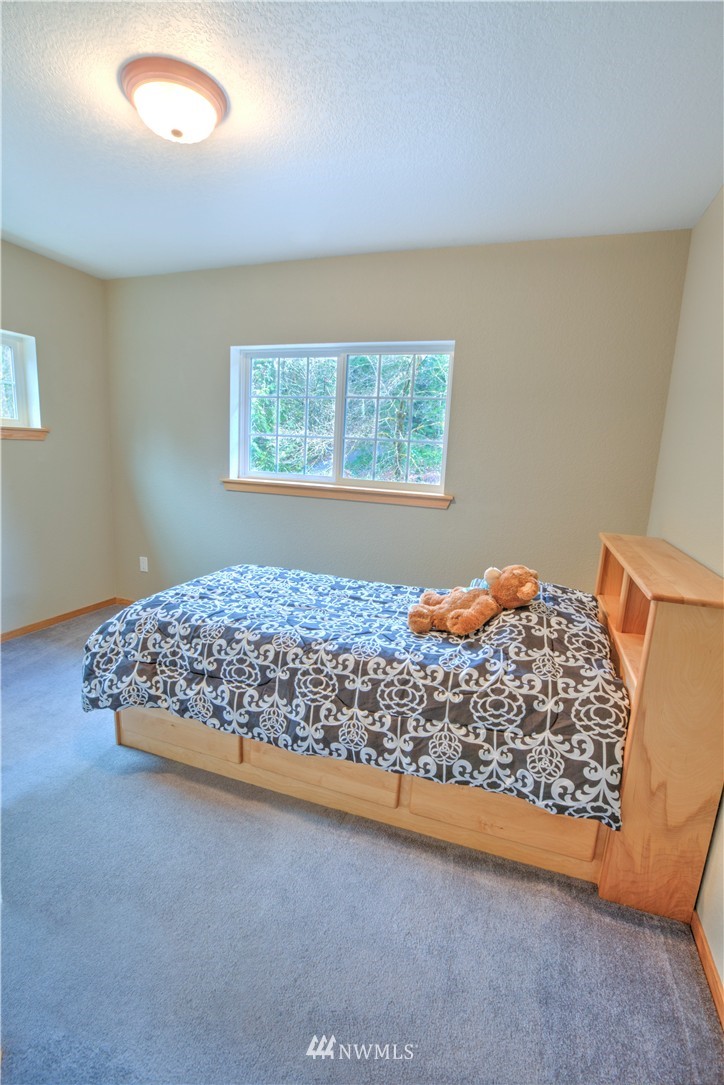 7736 Fairview Road Southwest Tumwater, WA 98512 - Photo 17 of 25 a bed sitting in a room next to a window