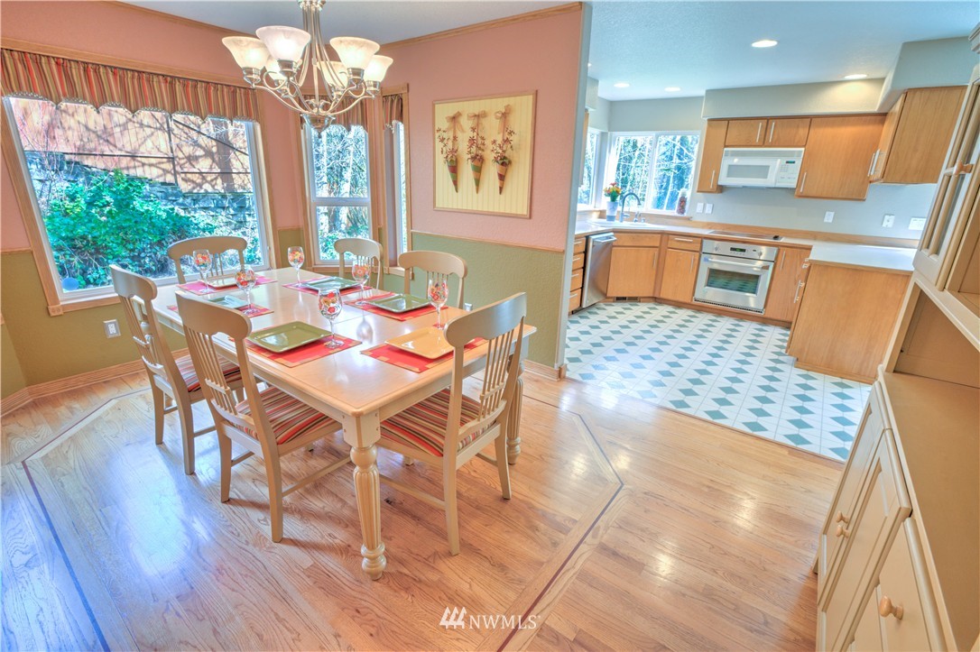 7736 Fairview Road Southwest Tumwater, WA 98512 - Photo 6 of 25 a view of a dining room with furniture a chandelier and wooden floor