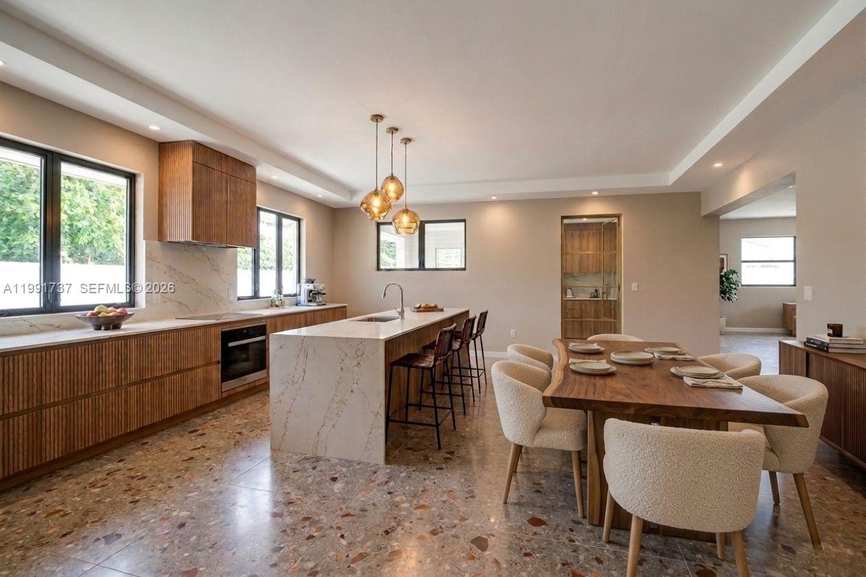 8285 Southwest 104th Street Miami, FL 33156 - Photo 2 of 21 a kitchen with a table chairs sink and cabinets