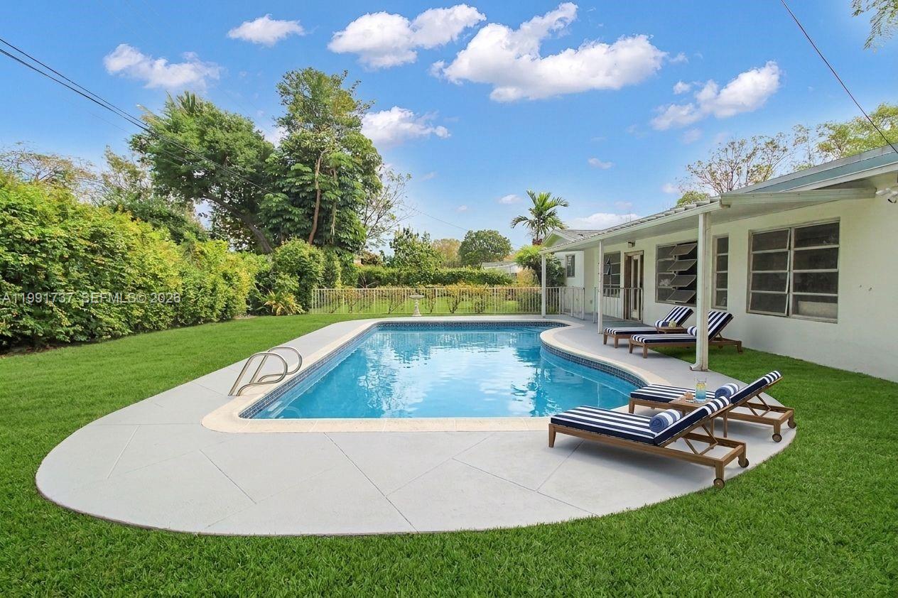 8285 Southwest 104th Street Miami, FL 33156 - Photo 7 of 21 a view of a swimming pool with lounge chairs in the patio