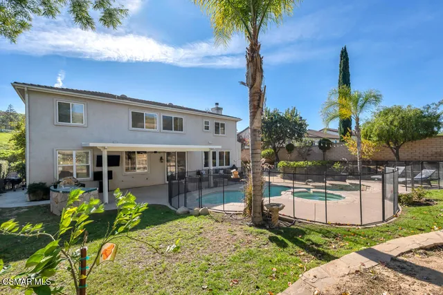 a view of a backyard with plants and large tree