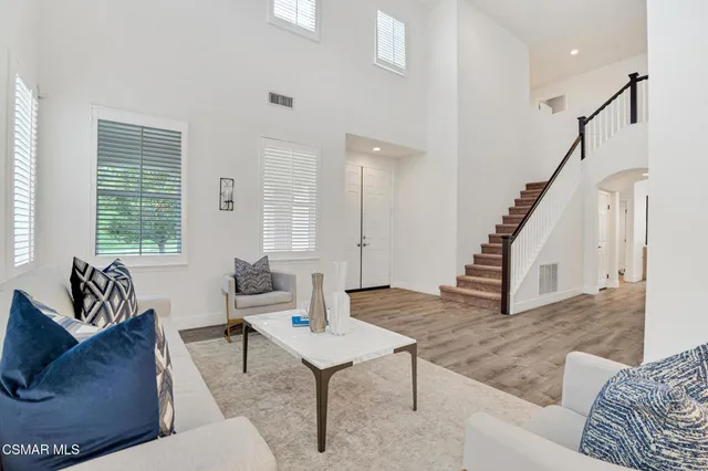 a dining room with furniture potted plants and wooden floor