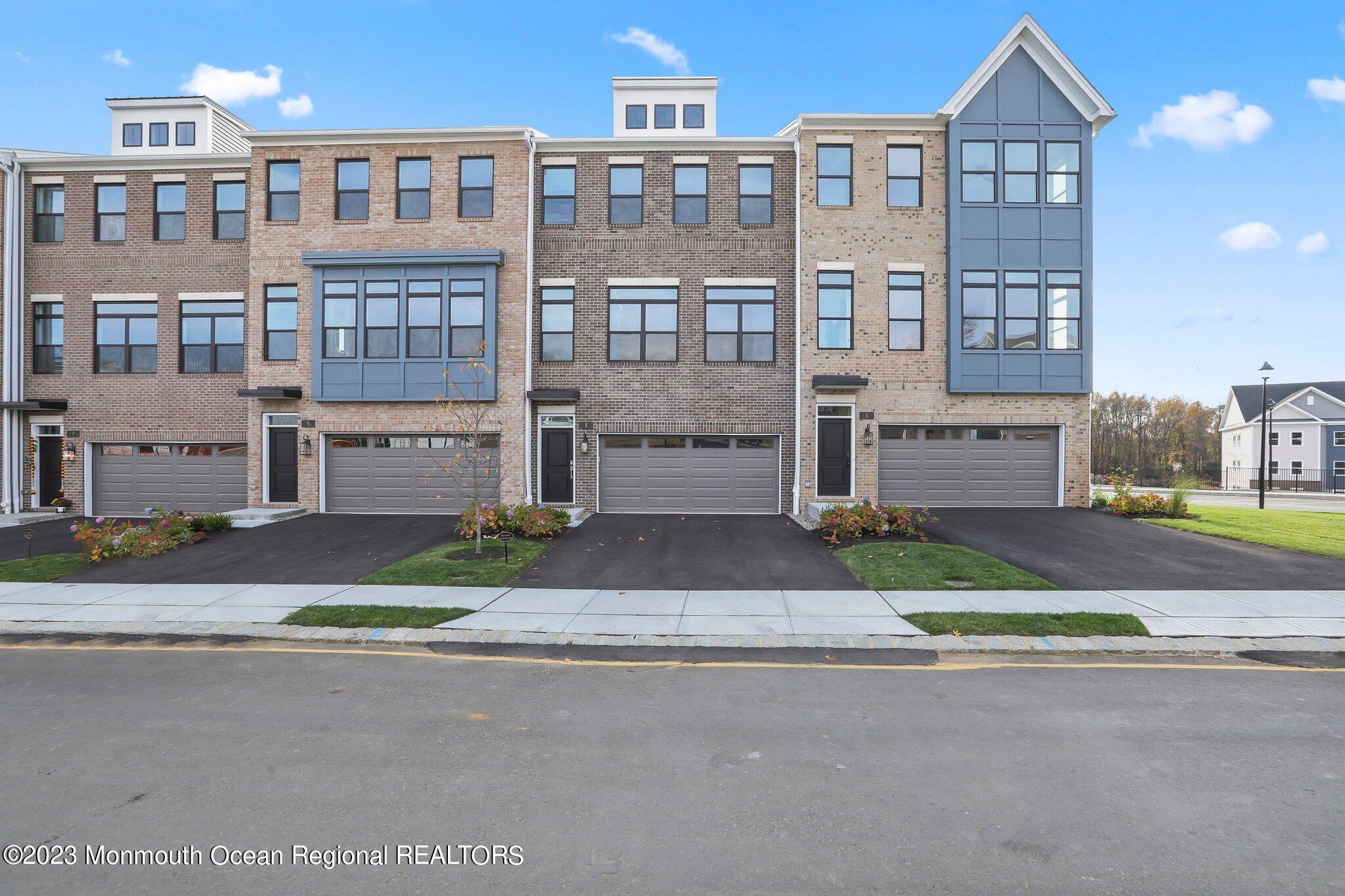 a front view of a building with a garden and entryway