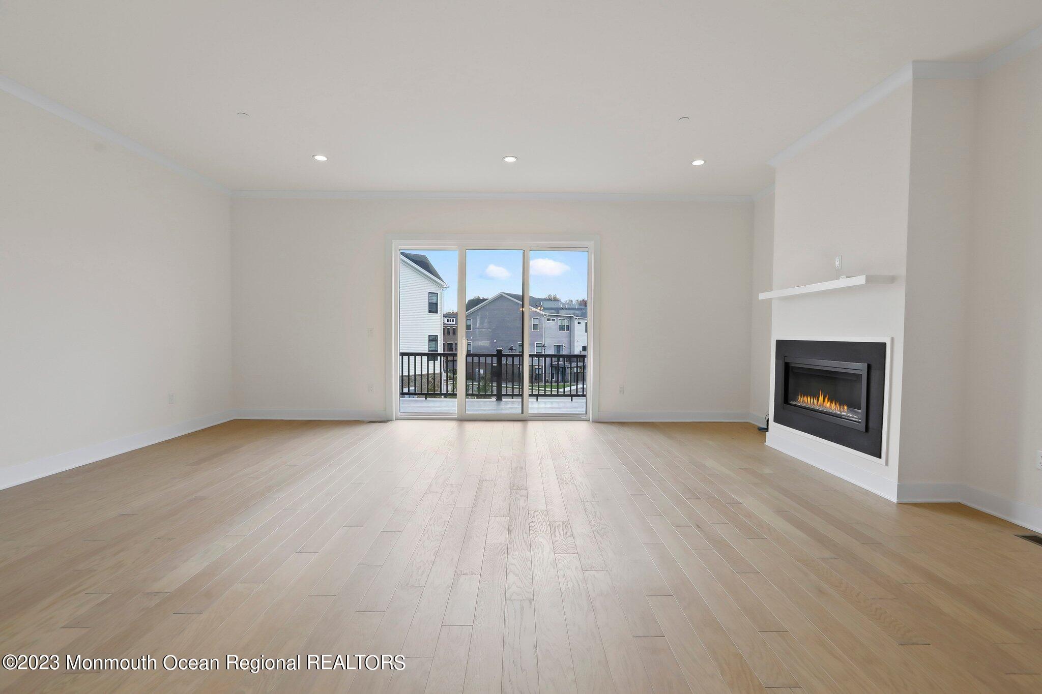 3 Valiant Court Middletown, NJ 07748 - Photo 11 of 42 an empty room with wooden floor and fireplace