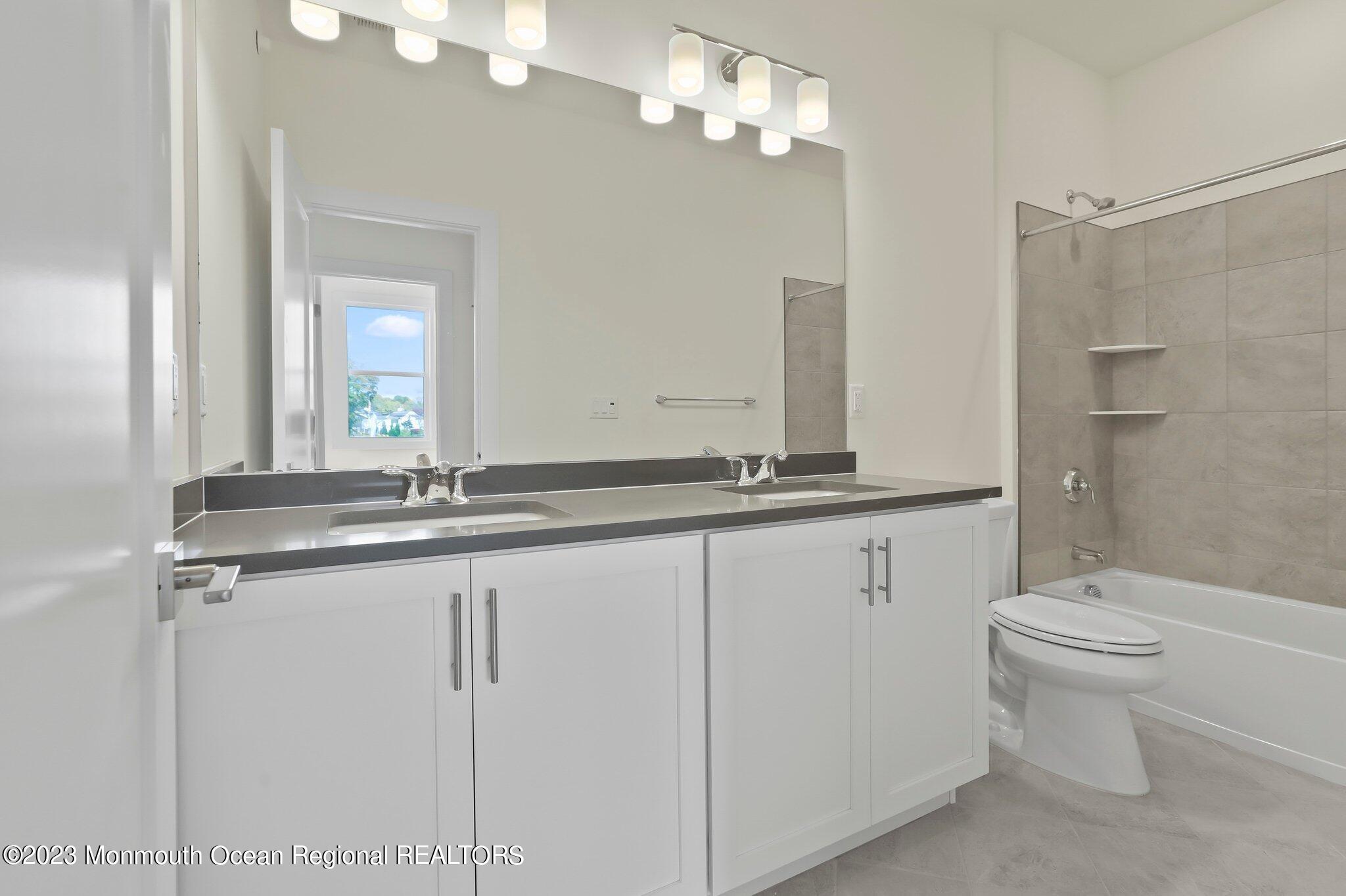 3 Valiant Court Middletown, NJ 07748 - Photo 22 of 42 a bathroom with a granite countertop sink a toilet and a mirror