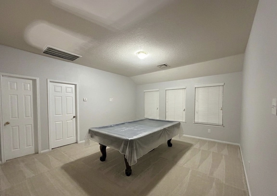 9908 Climbing Tree Street Conroe, TX 77385 - Photo 17 of 26 a living room with a table and gym equipment