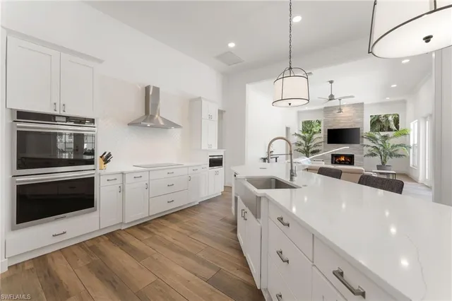 a large white bathroom with a granite countertop sink and a large mirror