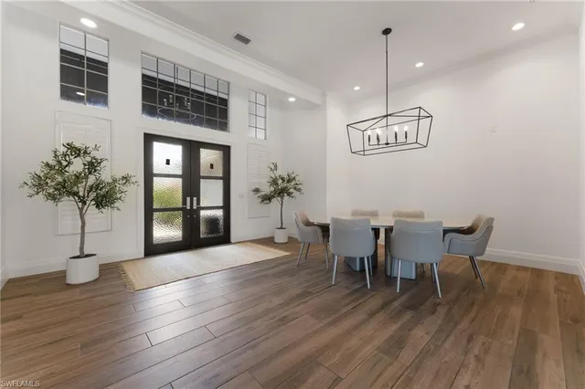 a kitchen with stainless steel appliances granite countertop a sink white cabinets and chairs