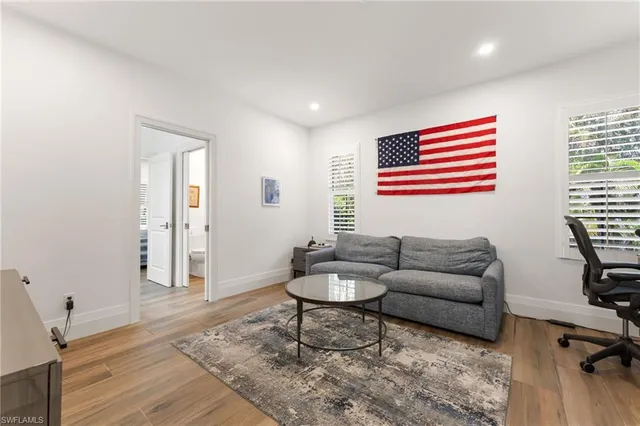 a view of a livingroom with wooden floor a fireplace and window