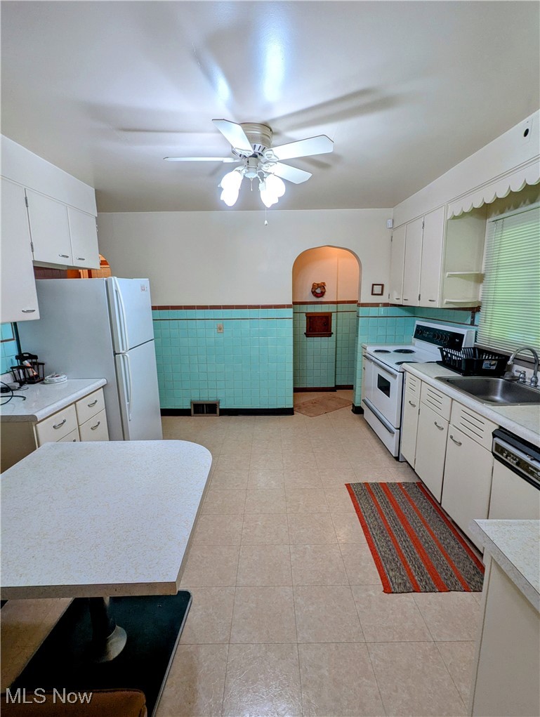 4965 Atchison Road Bellaire, OH 43906 - Photo 10 of 23 Kitchen featuring white appliances, wainscoting, ceiling fan, light countertops, and white cabinetry