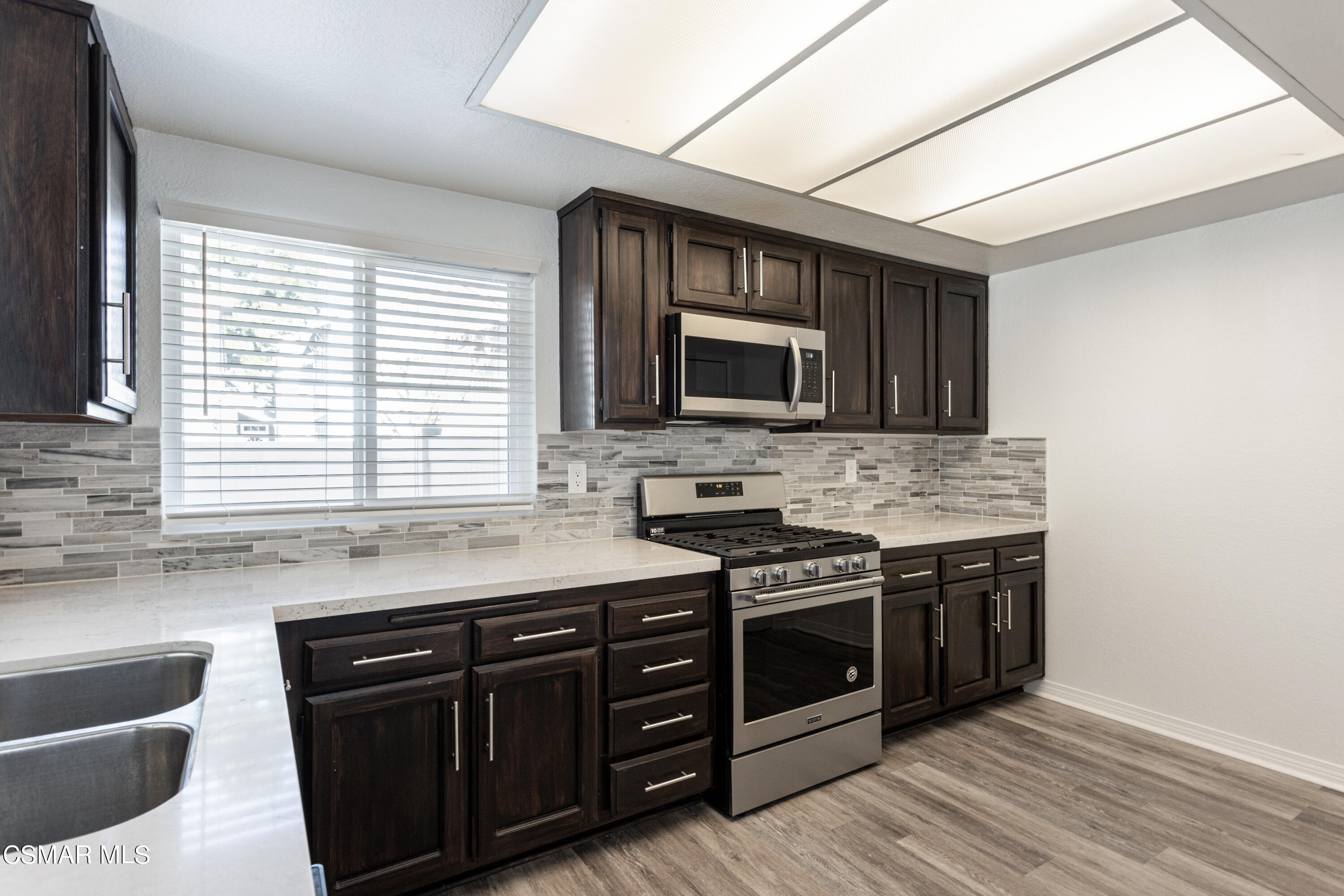1962 Rory Lane, Unit 2 Simi Valley, CA 93063 - Photo 7 of 21 a kitchen with stainless steel appliances granite countertop a stove a sink and a microwave