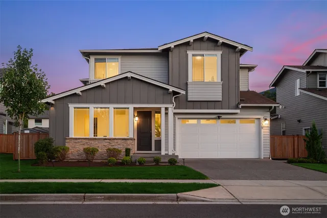 a front view of a house with a yard and garage
