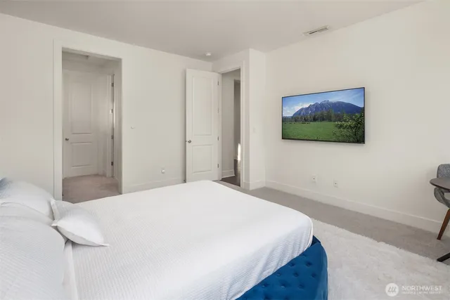 a bedroom with a bed and a flat screen tv