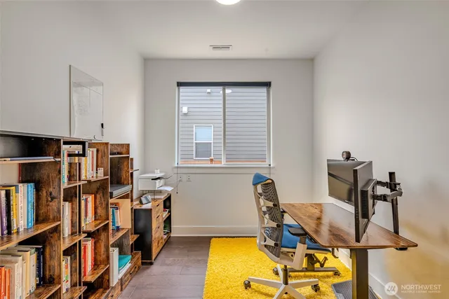 a view of a workspace with furniture and a bookshelf