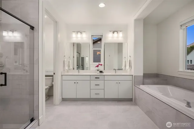 a spacious bathroom with a granite countertop tub sink shower and mirror