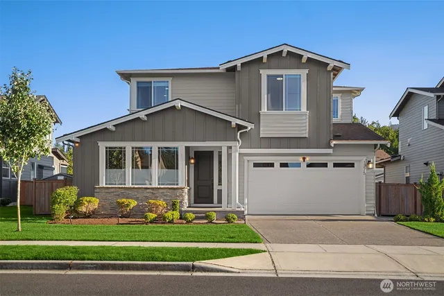a front view of a house with a yard and garage