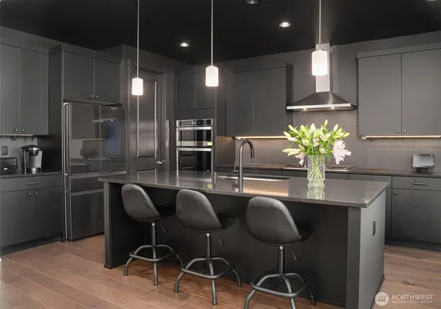 a kitchen with stainless steel appliances kitchen island granite countertop a dining table chairs and granite counter tops