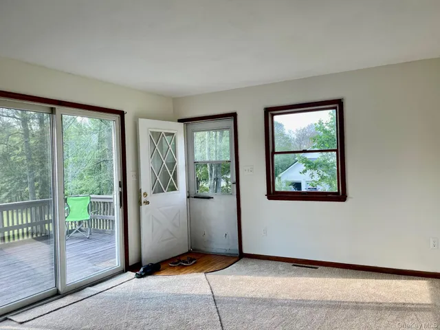 a view of an empty room with wooden floor and windows