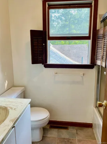 a bathroom with a granite countertop toilet and a sink
