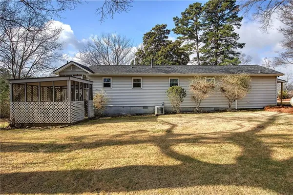 a view of a house with a yard and a large tree