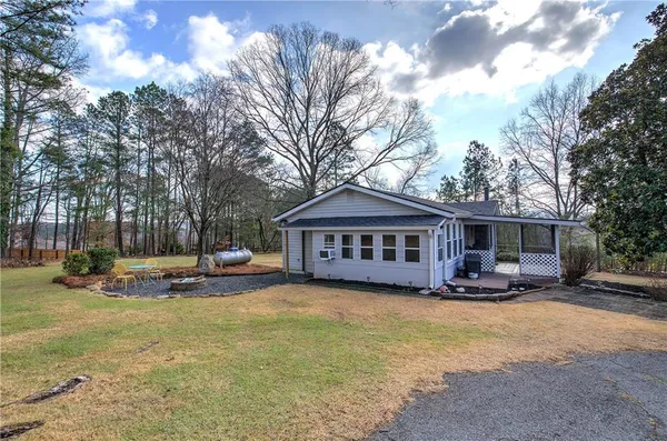 a front view of a house with yard patio and tree