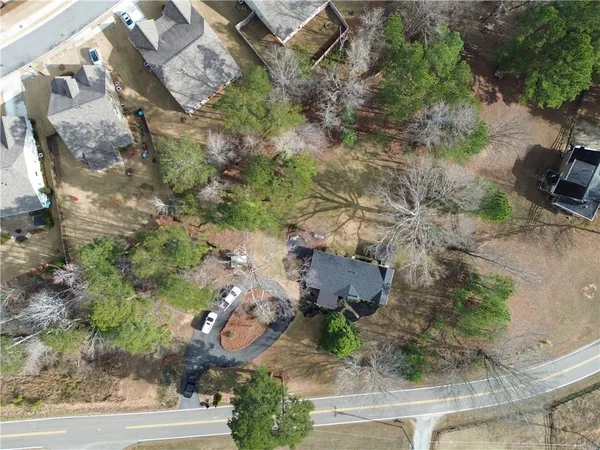 an aerial view of a house with a yard and greenery