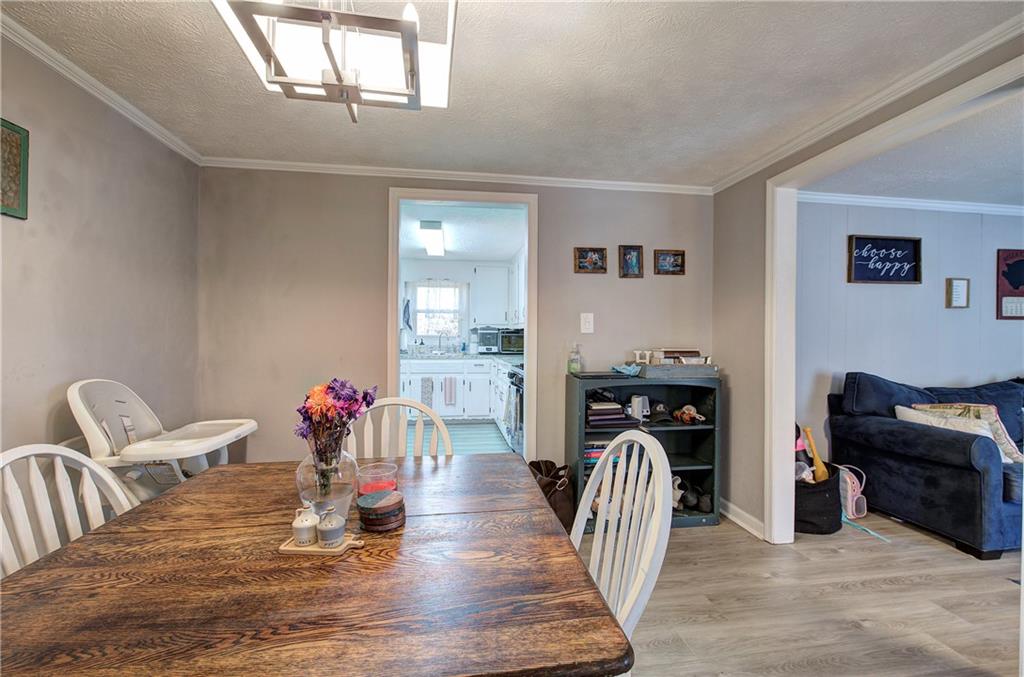 2023 Fate Conn Road Canton, GA 30114 - Photo 6 of 59 a dining room with furniture a chandelier and wooden floor