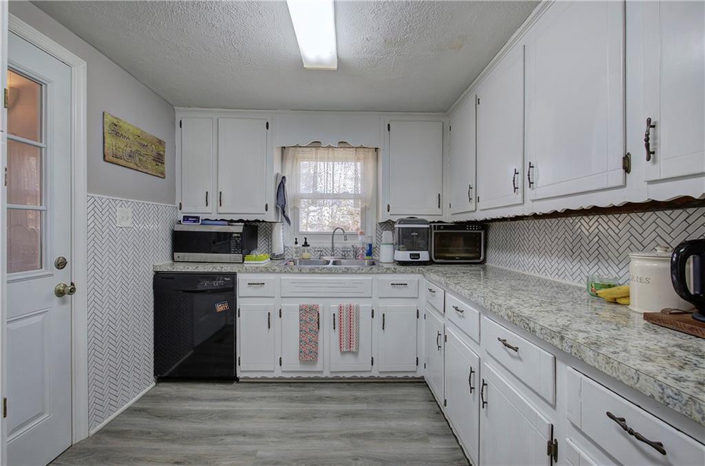 2023 Fate Conn Road Canton, GA 30114 - Photo 8 of 59 a kitchen with stainless steel appliances granite countertop a stove a sink and white cabinets