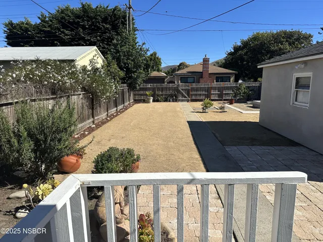 a view of a balcony with chairs and potted plants