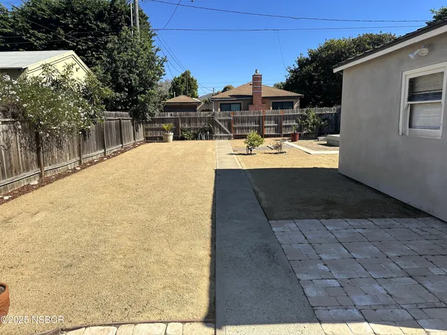 a view of backyard with swimming pool and seating space