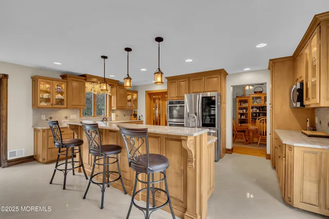 a kitchen with stainless steel appliances kitchen island granite countertop a table and chairs