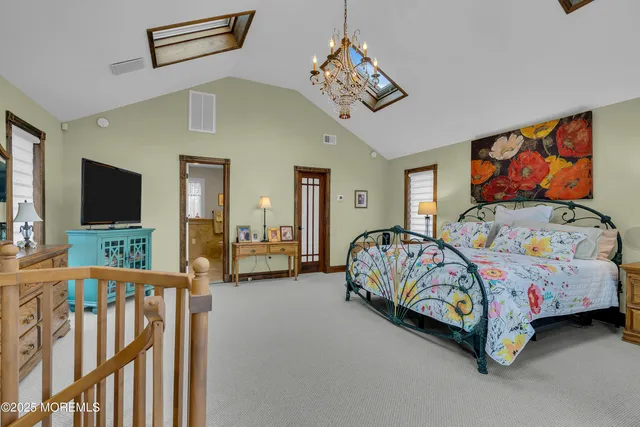 a bedroom with bed and a flat tv screen on dresser