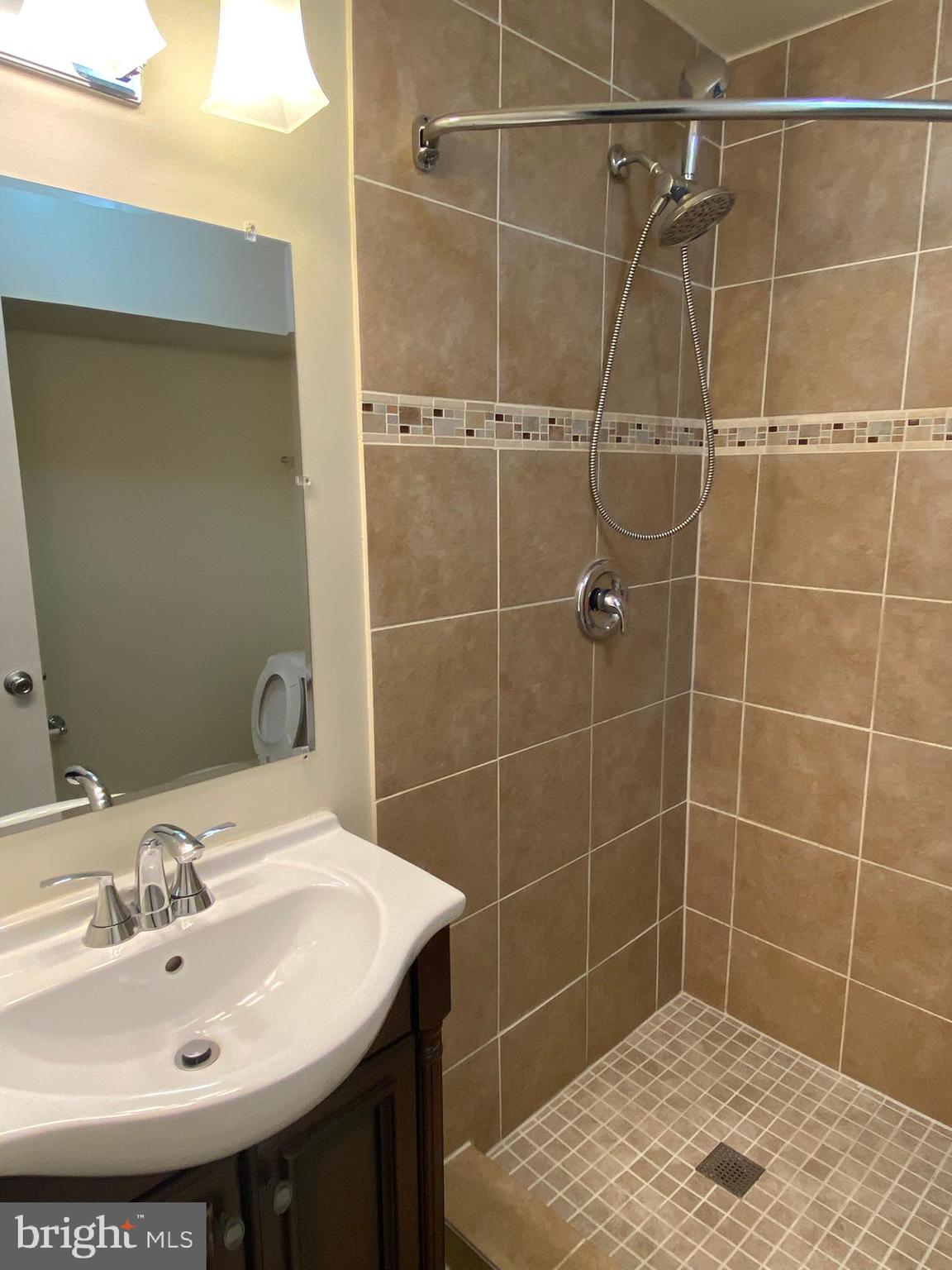 7432 Pohick Road Lorton, VA 22079 - Photo 12 of 27 a bathroom with a sink shower and a mirror