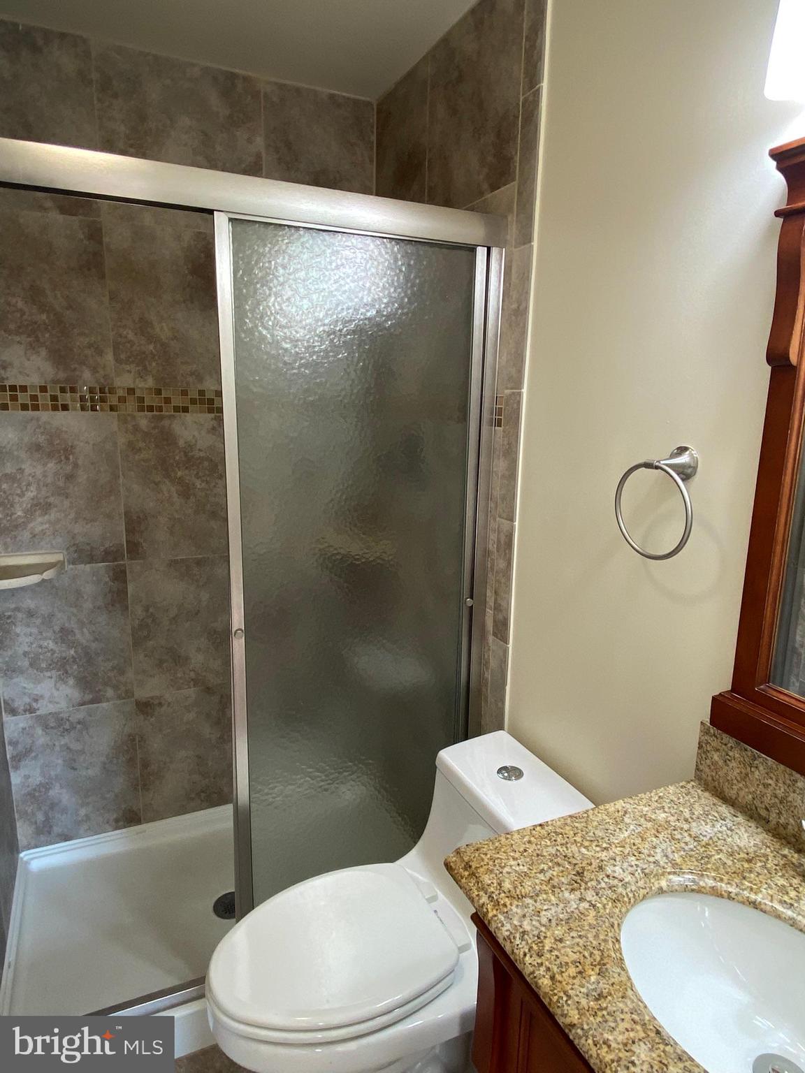 7432 Pohick Road Lorton, VA 22079 - Photo 17 of 27 a bathroom with a granite countertop sink toilet and shower