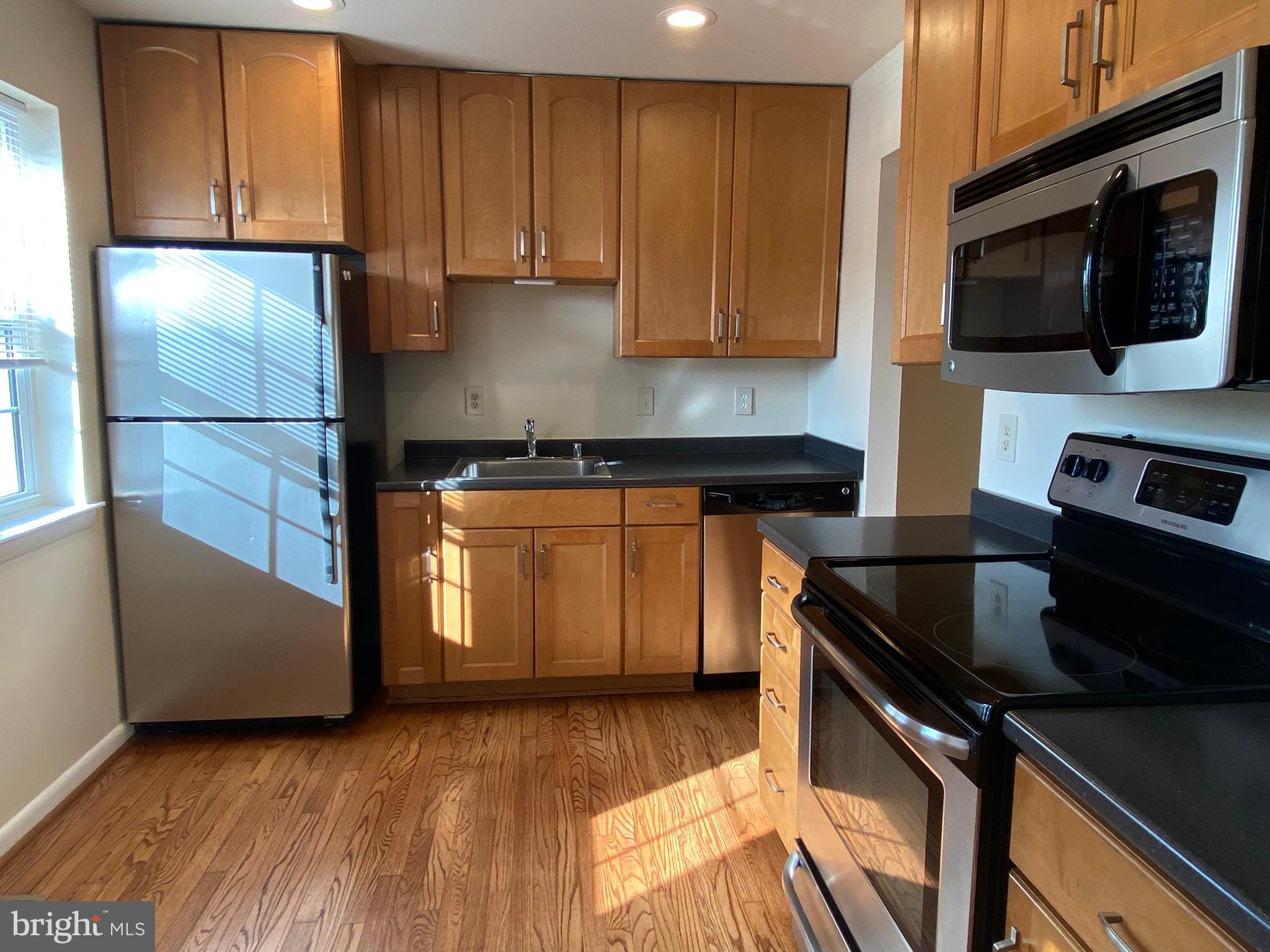 7432 Pohick Road Lorton, VA 22079 - Photo 2 of 27 a kitchen with a sink a microwave and cabinets