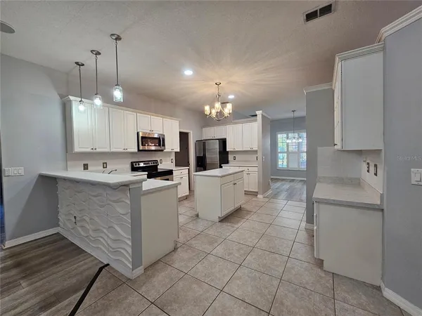 a kitchen with kitchen island granite countertop stainless steel appliances cabinets a sink and a counter top space