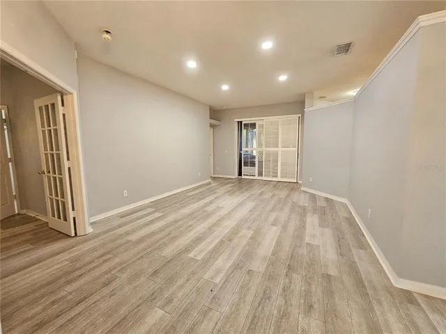 a view of empty room with wooden floor