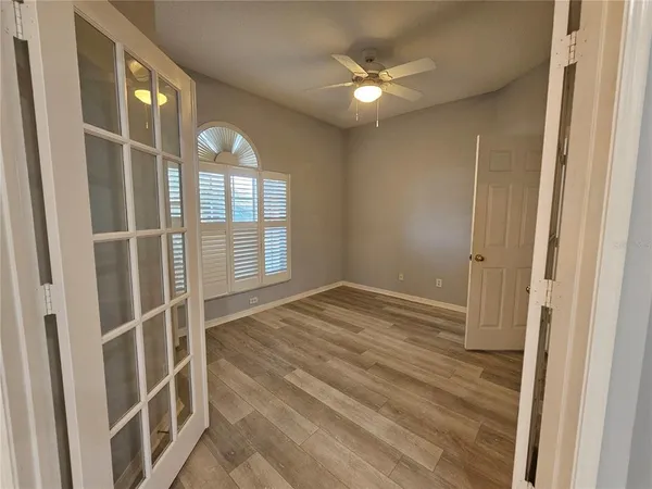 a view of an empty room with wooden floor and a window
