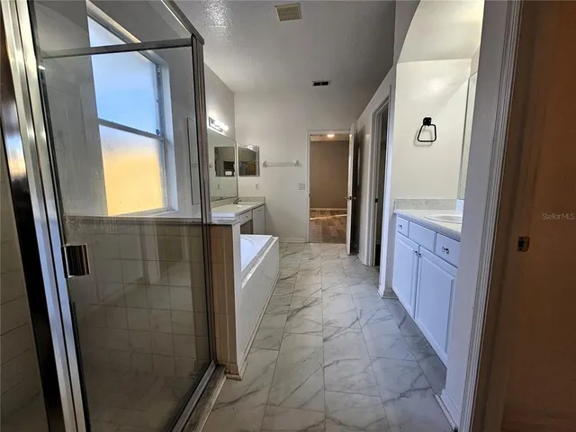 a bathroom with a glass door shower sink and mirror