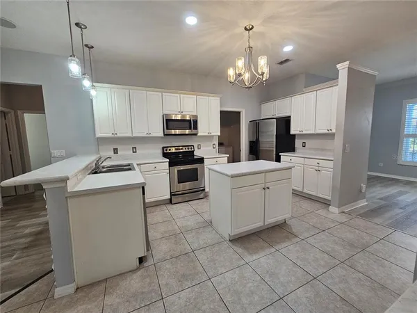 a kitchen with kitchen island granite countertop cabinets and white stainless steel appliances
