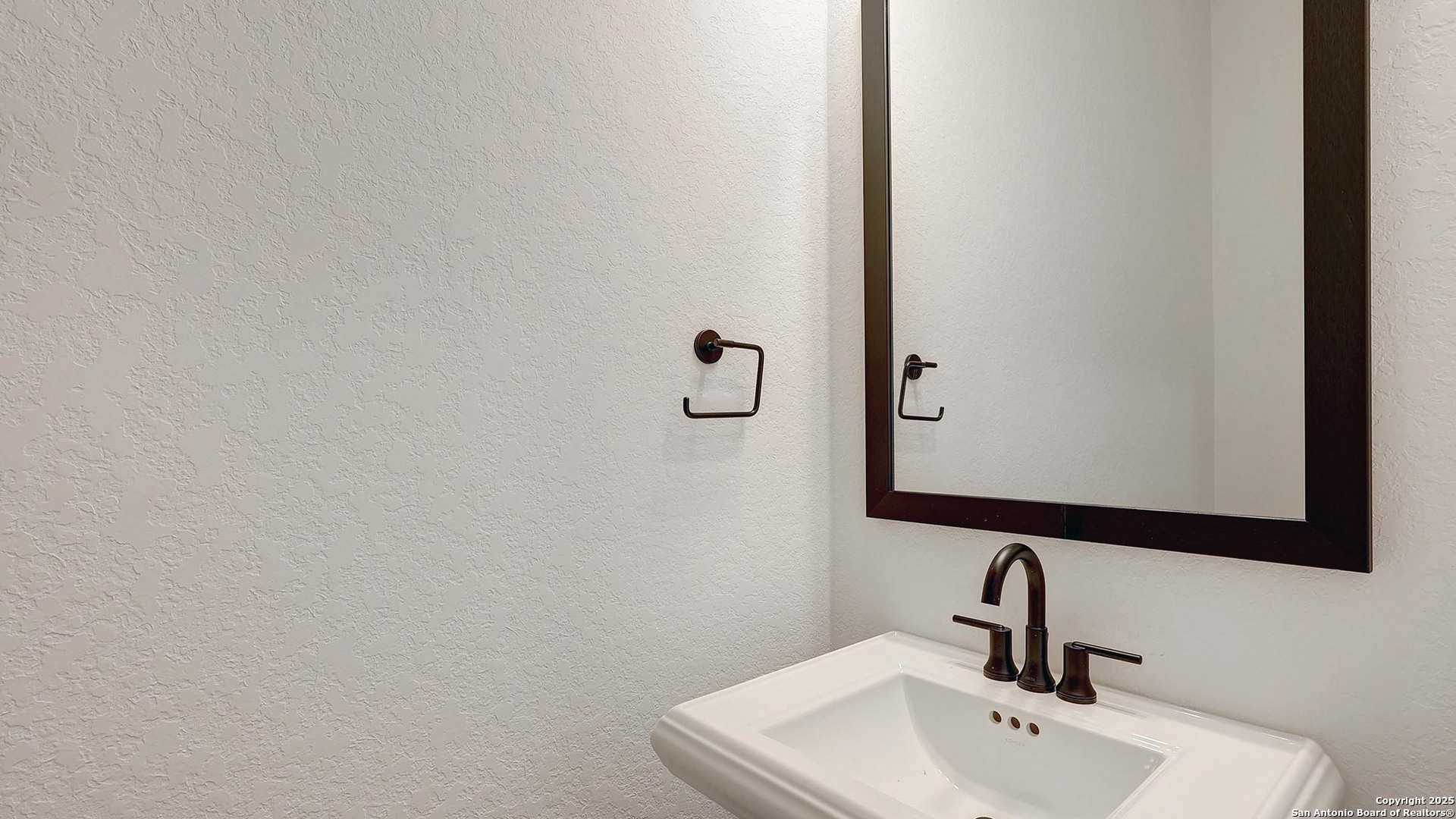 200 Violet Way Castroville, TX 78009 - Photo 22 of 32 a bathroom with a sink and mirror