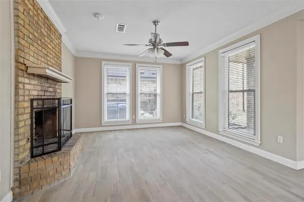 wooden floor fireplace and windows in an empty room