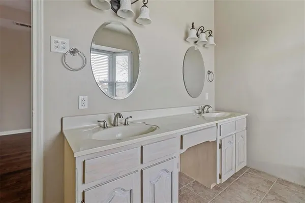 a bathroom with a double vanity sink and a mirror