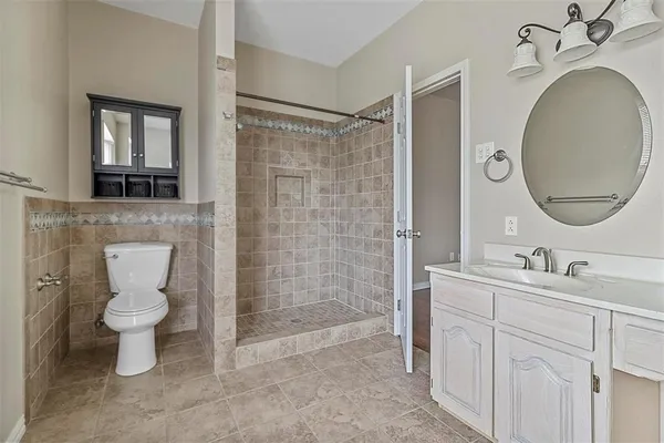 a bathroom with a toilet sink a mirror and shower